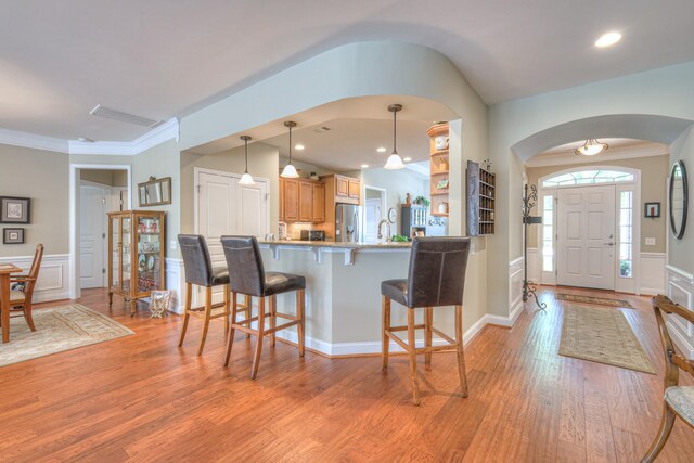 507 Bugler Rd, Mount Juliet, TN 37122 - kitchen with stainless steel fridge, arched walkways, a breakfast bar, light wood-style floors, and a decorative wall