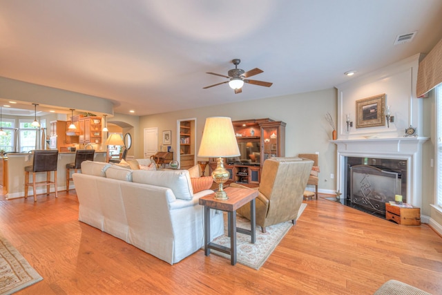 507 Bugler Rd, Mount Juliet, TN 37122 - living area featuring arched walkways, a fireplace with flush hearth, a ceiling fan, light wood-style flooring, and recessed lighting