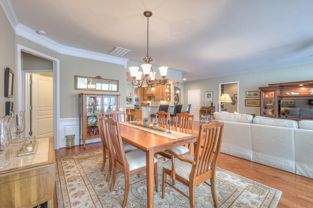 507 Bugler Rd, Mount Juliet, TN 37122 - dining area with a chandelier, light wood finished floors, crown molding, and a wainscoted wall