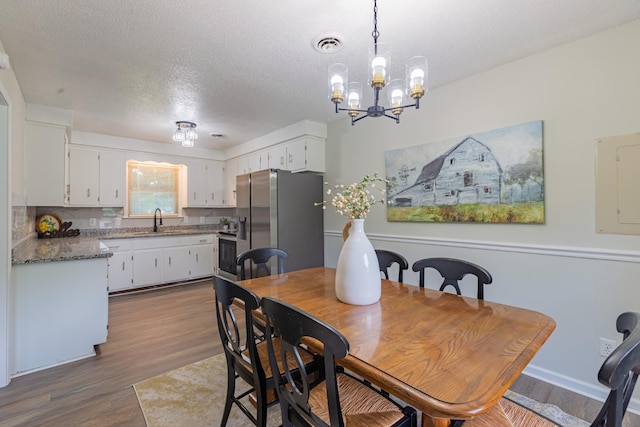 524 Inver Ln, Clarksville, TN 37042 - dining space featuring dark wood-style flooring, electric panel, a chandelier, and a textured ceiling