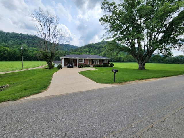 1036 Old Bottom Rd, Lafayette, TN 37083 - ranch-style home featuring concrete driveway, a front lawn, an attached carport, and a forest view