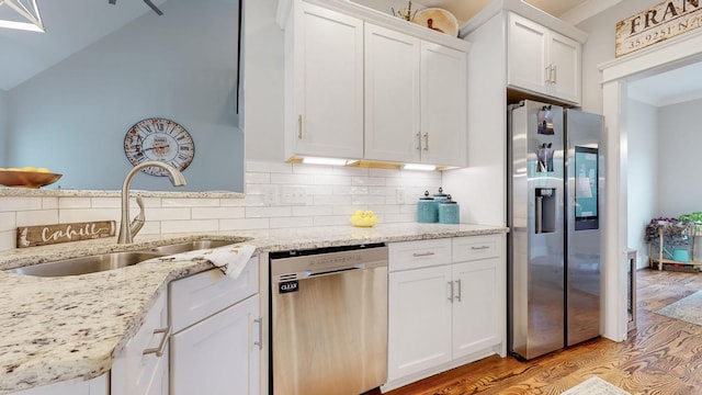 7146 Pepper Tree Cir, Fairview, TN 37062 - kitchen featuring stainless steel appliances, light wood finished floors, white cabinets, decorative backsplash, and light stone countertops