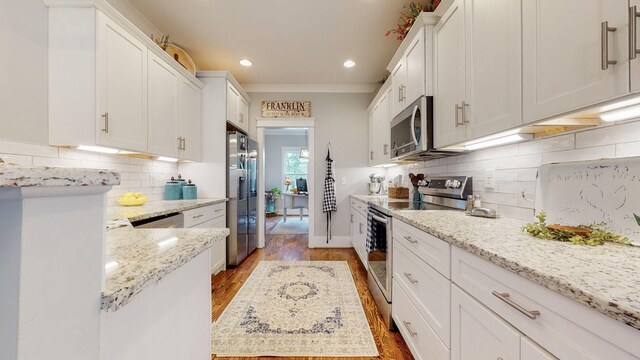 7146 Pepper Tree Cir, Fairview, TN 37062 - kitchen featuring stainless steel appliances, white cabinetry, light wood finished floors, tasteful backsplash, and recessed lighting
