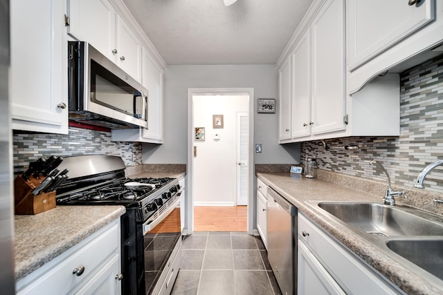 536 Deer Path, Gallatin, TN 37066 - kitchen with appliances with stainless steel finishes, white cabinets, backsplash, dark tile patterned floors, and light countertops