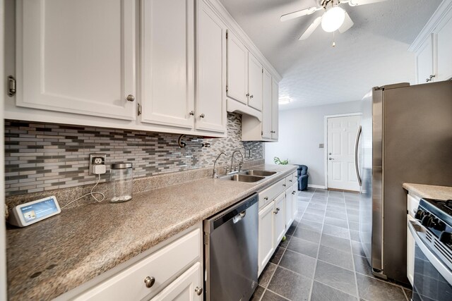 536 Deer Path, Gallatin, TN 37066 - kitchen with stainless steel appliances, tasteful backsplash, white cabinetry, ceiling fan, and dark tile patterned floors