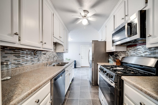 536 Deer Path, Gallatin, TN 37066 - kitchen featuring appliances with stainless steel finishes, white cabinets, ceiling fan, dark tile patterned floors, and tasteful backsplash