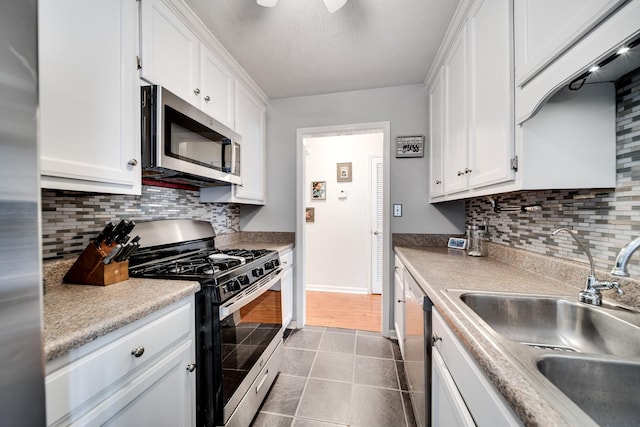 536 Deer Path, Gallatin, TN 37066 - kitchen with appliances with stainless steel finishes, white cabinets, dark tile patterned floors, decorative backsplash, and a textured ceiling