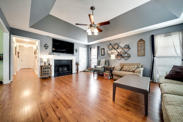 536 Deer Path, Gallatin, TN 37066 - living room with a tray ceiling, ceiling fan, light wood-type flooring, and a tiled fireplace