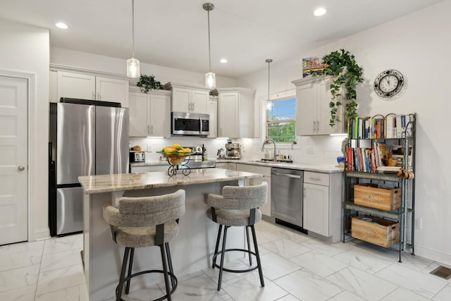 2968 Kirkwood Rd, Clarksville, TN 37043 - kitchen featuring appliances with stainless steel finishes, light marble finish flooring, a kitchen island, light stone countertops, and tasteful backsplash