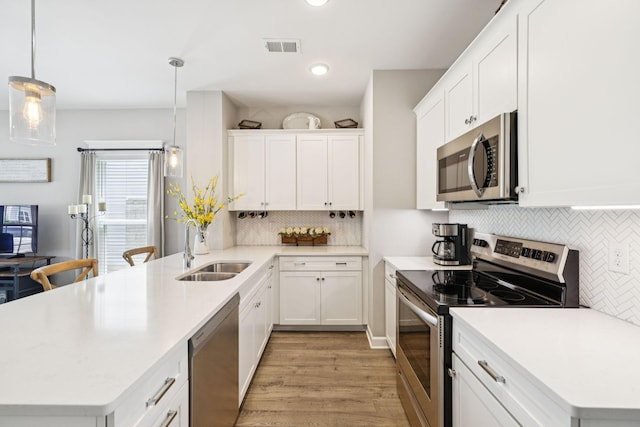 2515 Napa Valley Way, Columbia, TN 38401 - kitchen featuring stainless steel appliances, a peninsula, light wood-style floors, backsplash, and light countertops