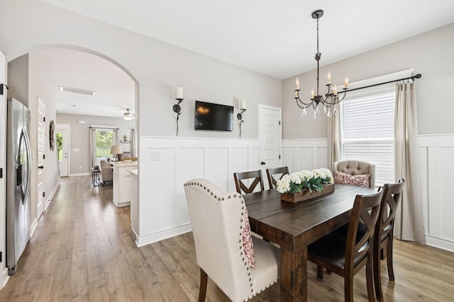 2515 Napa Valley Way, Columbia, TN 38401 - dining area featuring arched walkways, light wood-style floors, a chandelier, a wainscoted wall, and a decorative wall