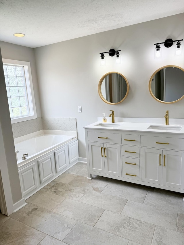 740 N Palmers Chapel Rd, White House, TN 37188 - bathroom with double vanity, a bath, and a textured ceiling
