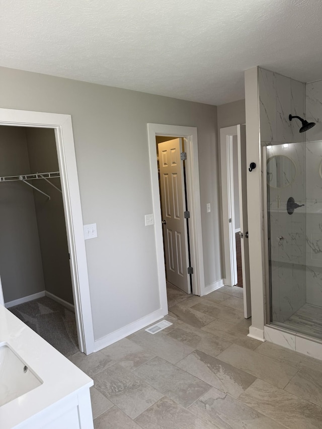 740 N Palmers Chapel Rd, White House, TN 37188 - full bathroom with a marble finish shower, vanity, a textured ceiling, and a spacious closet