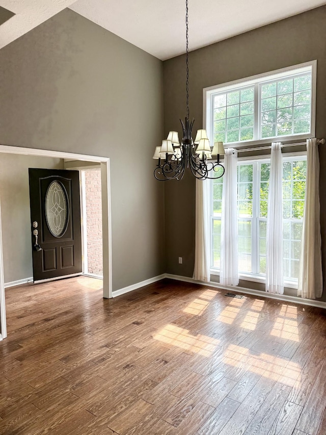 740 N Palmers Chapel Rd, White House, TN 37188 - unfurnished dining area featuring a chandelier, wood finished floors, and a towering ceiling