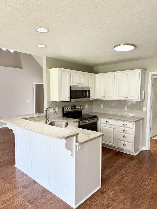 740 N Palmers Chapel Rd, White House, TN 37188 - kitchen featuring range with electric stovetop, stainless steel microwave, a peninsula, a textured ceiling, and white cabinets