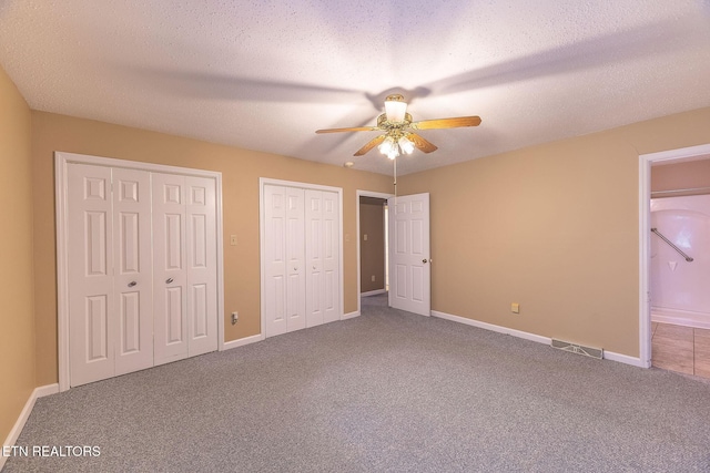 100 Cusick Cir, Lenoir City, TN 37772 - unfurnished bedroom featuring two closets, carpet flooring, ceiling fan, and a textured ceiling
