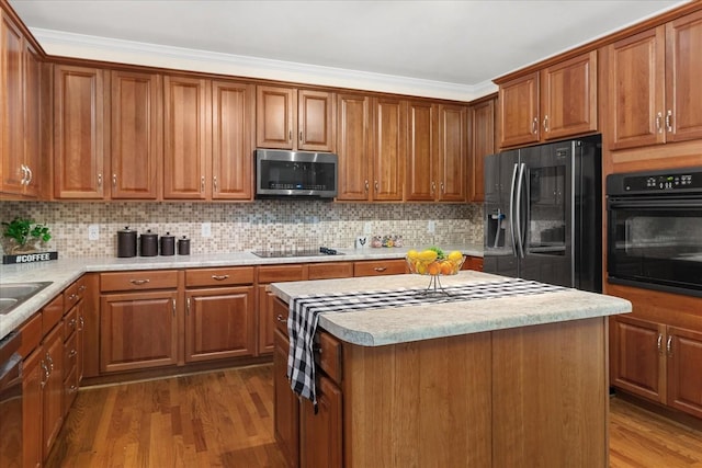 1164 Sydney Ter, Mount Juliet, TN 37122 - kitchen featuring black appliances, brown cabinets, light countertops, tasteful backsplash, and crown molding
