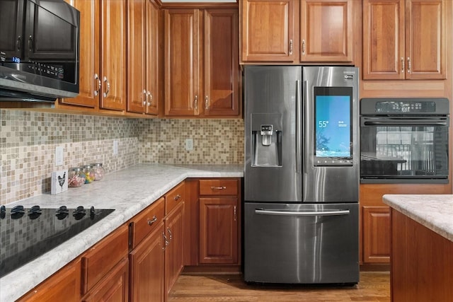 1164 Sydney Ter, Mount Juliet, TN 37122 - kitchen featuring black appliances, brown cabinetry, tasteful backsplash, and light countertops