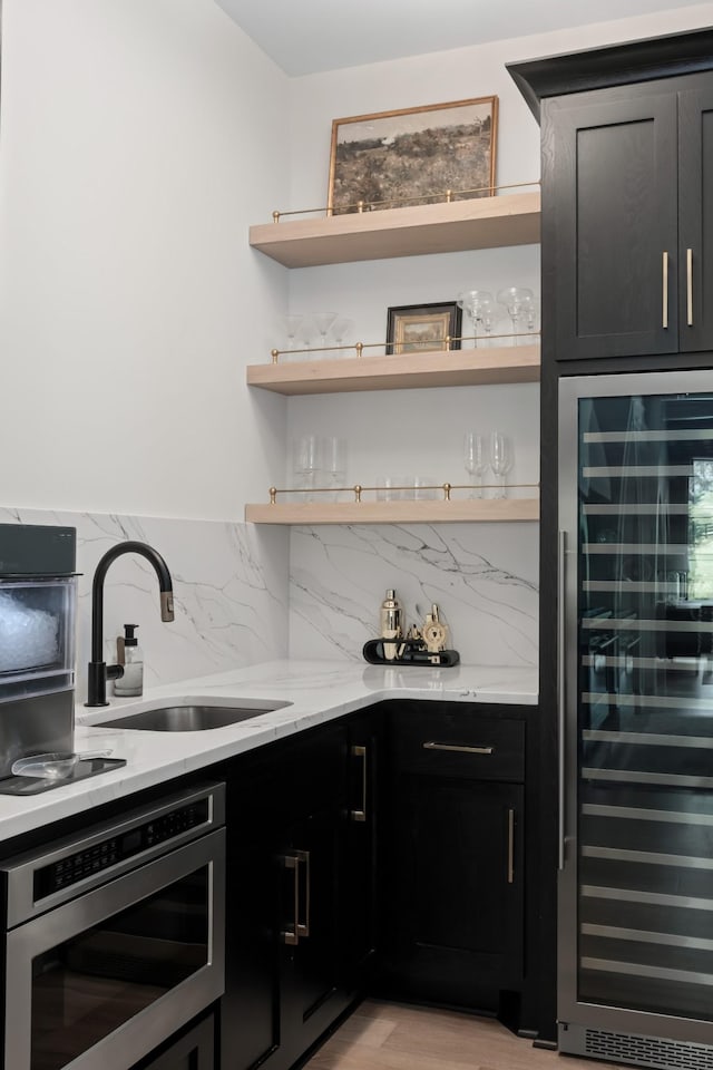 4896 Bethesda Rd, Thompsons Station, TN 37179 - indoor bar with wine cooler, decorative backsplash, wall oven, light wood-style flooring, and stainless steel microwave