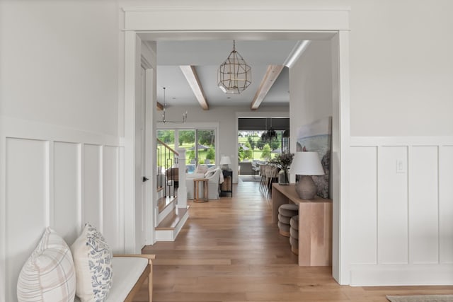 4896 Bethesda Rd, Thompsons Station, TN 37179 - hallway with beamed ceiling, a chandelier, a decorative wall, wood finished floors, and stairway