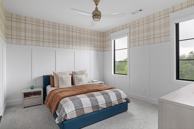 4896 Bethesda Rd, Thompsons Station, TN 37179 - bedroom featuring wallpapered walls, light carpet, a decorative wall, a ceiling fan, and wainscoting