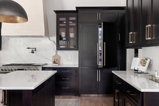 4896 Bethesda Rd, Thompsons Station, TN 37179 - kitchen with light wood finished floors, glass insert cabinets, light stone counters, high quality fridge, and tasteful backsplash