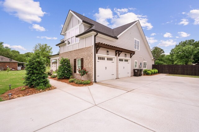 2207 Sulphur Springs Rd, Murfreesboro, TN 37129 - view of side of home with driveway, brick siding, an attached garage, board and batten siding, and roof with shingles