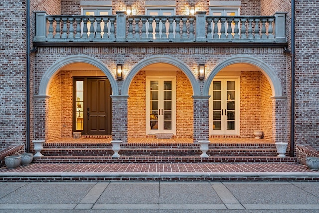 2455 Hidden River Ln, Franklin, TN 37069 - property entrance featuring a balcony, brick siding, french doors, and covered porch