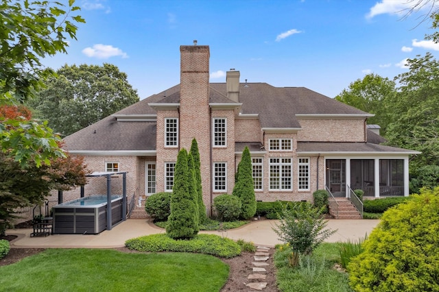 2455 Hidden River Ln, Franklin, TN 37069 - rear view of house featuring a patio, a sunroom, a hot tub, a chimney, and brick siding