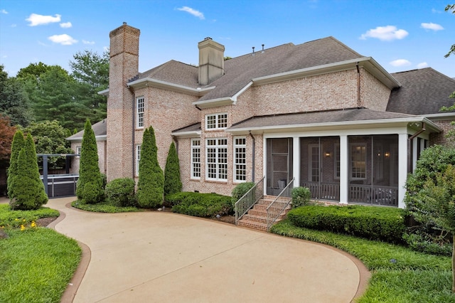 2455 Hidden River Ln, Franklin, TN 37069 - back of house with a sunroom, a chimney, brick siding, and roof with shingles