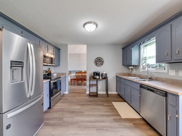 3786 Man O War Blvd, Clarksville, TN 37042 - kitchen with appliances with stainless steel finishes, a textured ceiling, light wood-style flooring, light countertops, and blue cabinets