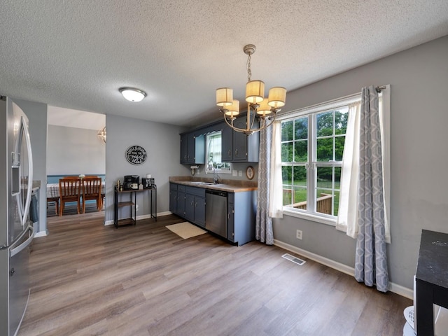 3786 Man O War Blvd, Clarksville, TN 37042 - kitchen featuring a chandelier, appliances with stainless steel finishes, wood finished floors, a textured ceiling, and light countertops