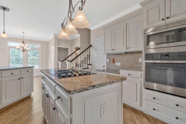 375 Natchez Trace Ct, Murfreesboro, TN 37127 - kitchen featuring appliances with stainless steel finishes, decorative backsplash, light wood-type flooring, a kitchen island, and a chandelier