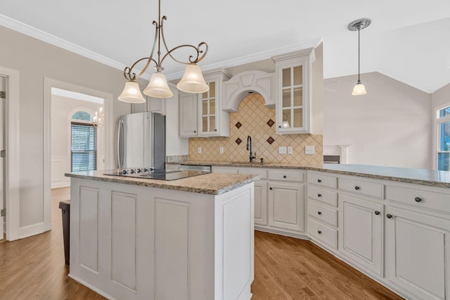 375 Natchez Trace Ct, Murfreesboro, TN 37127 - kitchen featuring black electric stovetop, freestanding refrigerator, a kitchen island, backsplash, and light wood-style floors