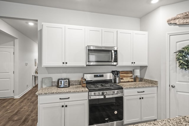 2028 Tate Farm Ln, White House, TN 37188 - kitchen featuring appliances with stainless steel finishes, white cabinets, light stone counters, dark wood-type flooring, and recessed lighting
