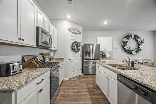 2028 Tate Farm Ln, White House, TN 37188 - kitchen with appliances with stainless steel finishes, dark wood finished floors, recessed lighting, white cabinets, and light stone countertops