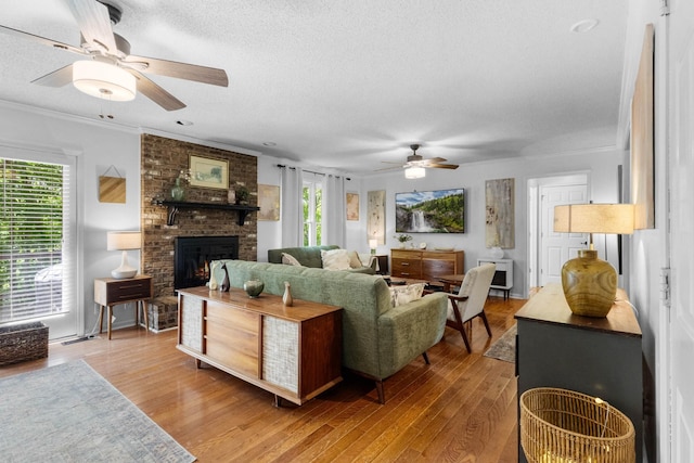 1830 Bradbury Rd, Adams, TN 37010 - living area with ceiling fan, a textured ceiling, a fireplace, wood finished floors, and crown molding