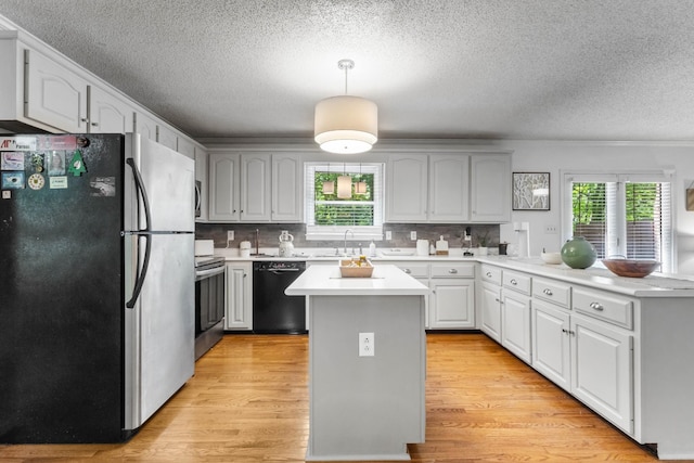 1830 Bradbury Rd, Adams, TN 37010 - kitchen with appliances with stainless steel finishes, a textured ceiling, plenty of natural light, light wood finished floors, and a peninsula