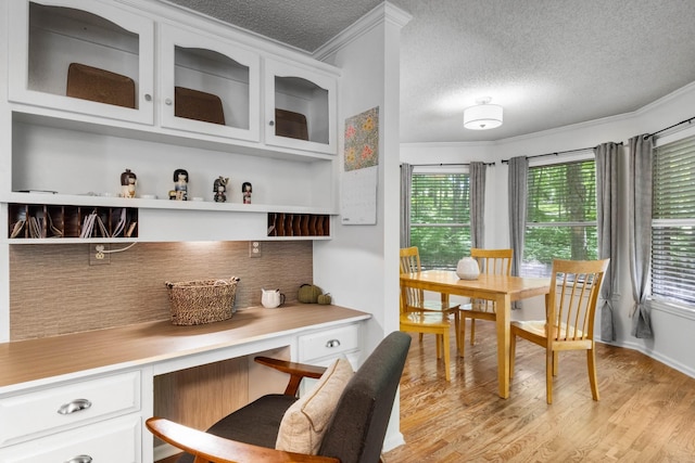 1830 Bradbury Rd, Adams, TN 37010 - kitchen with built in desk, crown molding, white cabinetry, glass insert cabinets, and backsplash