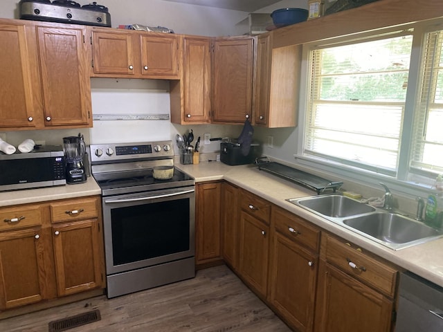3701 Juandale Trl, Chattanooga, TN 37406 - kitchen with stainless steel appliances, light countertops, brown cabinetry, and wood finished floors
