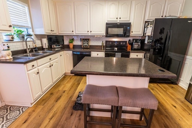 1699 Burnt Oak Dr Unit 195, Dalton, GA 30721 - kitchen featuring black appliances, dark countertops, a breakfast bar, and light wood-type flooring