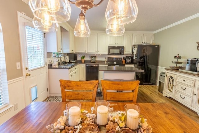 1699 Burnt Oak Dr Unit 195, Dalton, GA 30721 - kitchen with black appliances, dark countertops, a kitchen island, crown molding, and white cabinetry