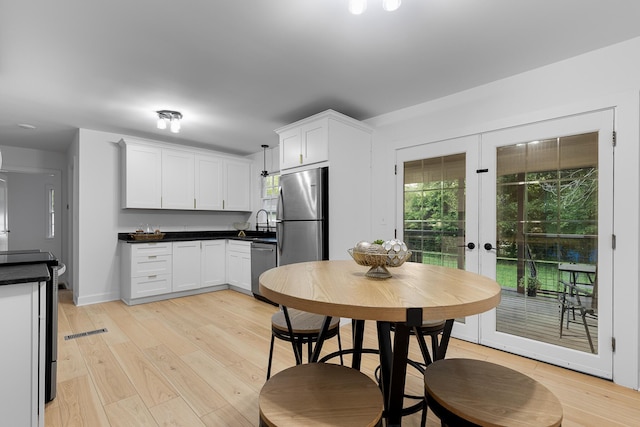 109 Anderson Dr, Chattanooga, TN 37421 - kitchen with dark countertops, stainless steel appliances, french doors, and light wood-style flooring