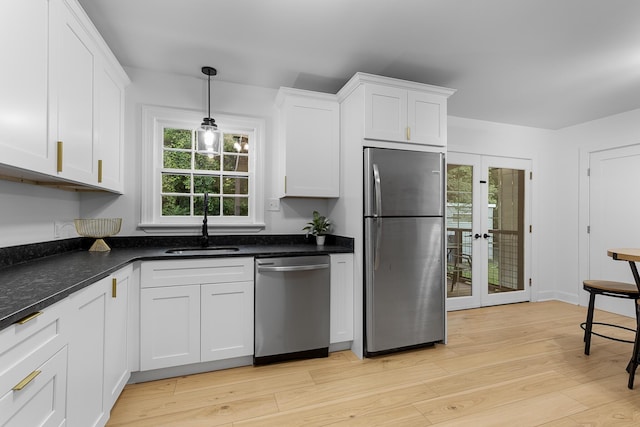 109 Anderson Dr, Chattanooga, TN 37421 - kitchen featuring appliances with stainless steel finishes, white cabinetry, light wood-style flooring, and decorative light fixtures