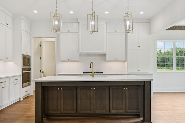 508 Matthew Miller Dr, Smyrna, TN 37167 - kitchen with stainless steel appliances, decorative backsplash, an island with sink, white cabinets, and recessed lighting