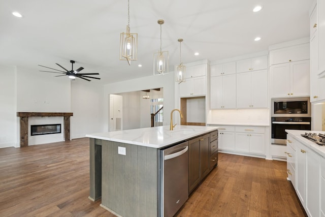 508 Matthew Miller Dr, Smyrna, TN 37167 - kitchen featuring stainless steel appliances, white cabinetry, recessed lighting, a glass covered fireplace, and wood finished floors