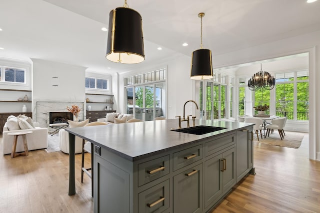 8876 Edgecomb Dr, College Grove, TN 37046 - kitchen with gray cabinetry, light wood finished floors, a chandelier, a kitchen island with sink, and a premium fireplace
