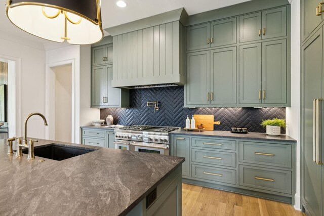 8876 Edgecomb Dr, College Grove, TN 37046 - kitchen featuring green cabinets, high end stainless steel range, backsplash, custom exhaust hood, and dark stone countertops