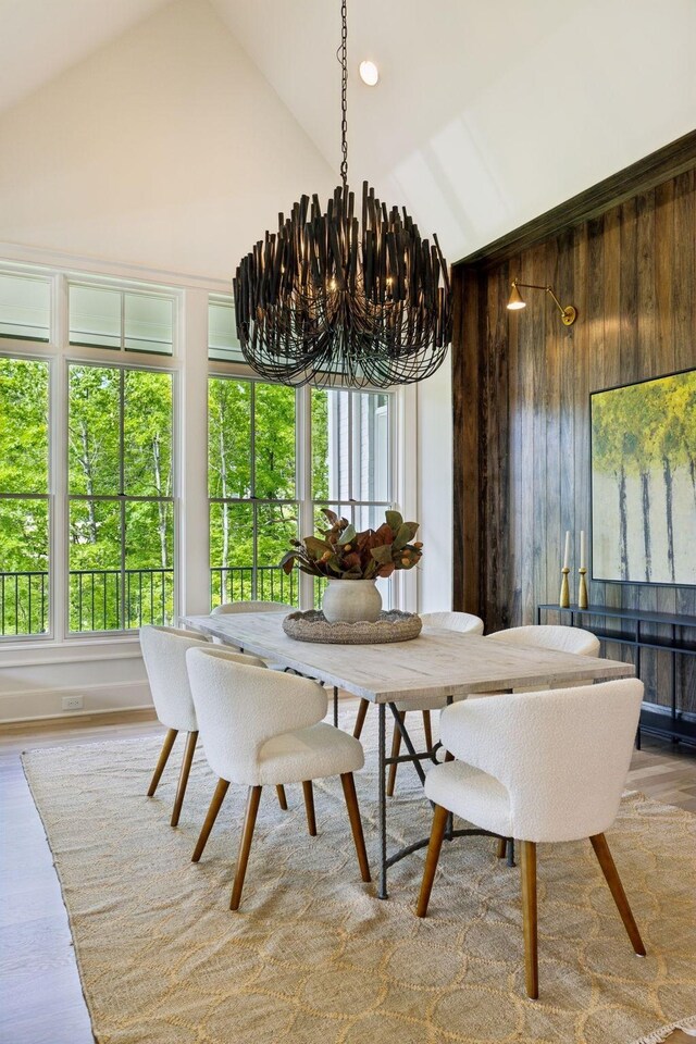 8876 Edgecomb Dr, College Grove, TN 37046 - dining room featuring a chandelier, wood finished floors, wood walls, and high vaulted ceiling