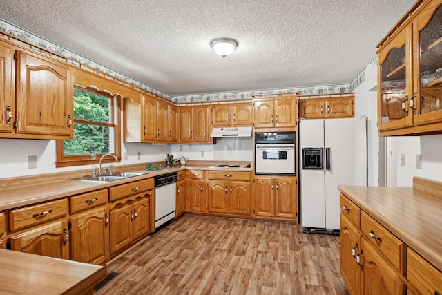 8663 Dog Branch Rd, Mount Pleasant, TN 38474 - kitchen with white appliances, light wood finished floors, a textured ceiling, under cabinet range hood, and brown cabinetry